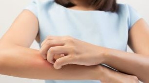 Kvinna kliar sig på armen